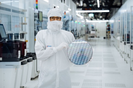 Ein Techniker im Reinraum von Infineon Technologies in Villach, Österreich, hält einen 300 mm Galliumnitrid-Wafer.