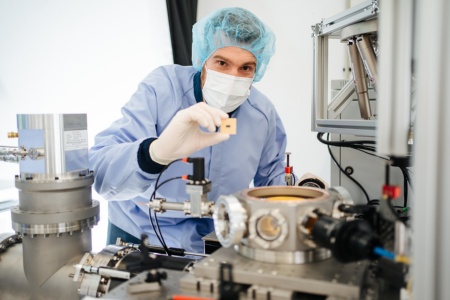 Engineer with quantum chip in Ion trap laboratory from Infineon in Villach/ Austria